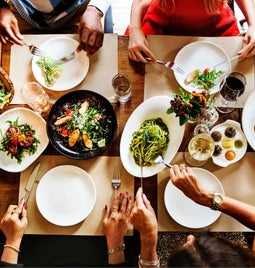 Group eat around a table covered with plates of food