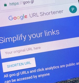 Phone in pocket showing the Google URL Shortener tool homepage