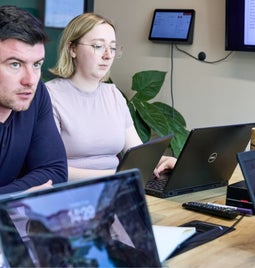 Business colleagues with serious expressions discussing a business matter in an office setting