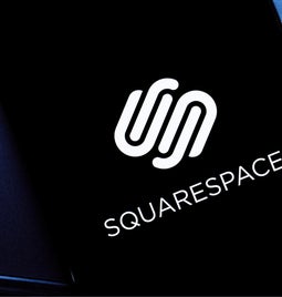 Mobile with a black screen showing the Squarespace logo