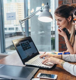 two females looking at a laptop screen