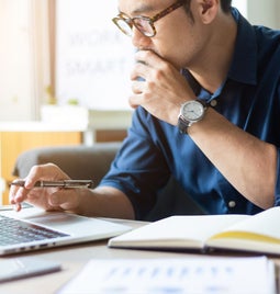 A man looking at his laptop while looking.