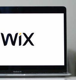 Laptop with a white screen showing the Wix logo